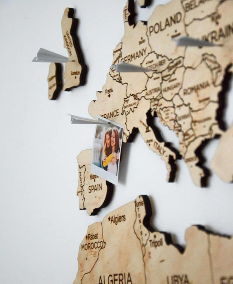 drewniana mapa na ścianie samoloty pinezki